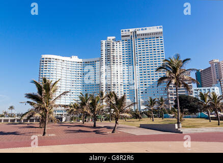 Passeggiata e alberi di palma contro lo skyline della città sulla spiaggia Foto Stock
