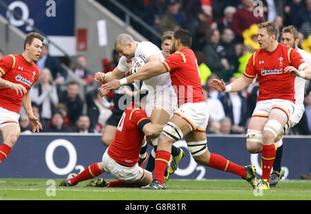 Mike Brown in Inghilterra viene affrontato da Dan Biggar (a sinistra) e Taulupe Faletau (a destra) nel corso della partita delle sei Nazioni RBS 2016 allo stadio Twickenham di Londra. Foto Stock