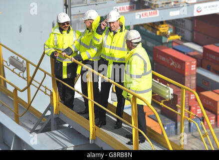 Il Duca di Cambridge (seconda a destra) tiene sul suo elmetto mentre una raffica di vento lo cattura mentre si trova su un gantry in cima ad una delle gru di container della nave, con il presidente del DP Sultan Ahmed Bin Sulayem (a sinistra), Lord Hague (seconda a sinistra) e il CEO del DP Simon Moore, Durante una visita al DP World's London Gateway, porto dei container a Stanford-le-Hope, Essex. Foto Stock