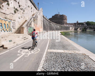 Donna sul percorso ciclabile vicino al fiume Tevere con Castel Sant'Angelo a Roma, Italia Foto Stock