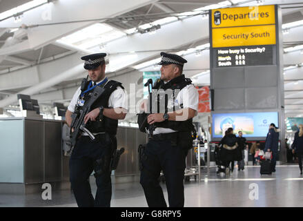 Gli agenti di polizia armati pattugliano all'interno del Terminal 5 dell'aeroporto di Heathrow a Londra, poiché la sicurezza è stata rafforzata nei centri di trasporto nel Regno Unito dopo gli attacchi terroristici a Bruxelles. Foto Stock