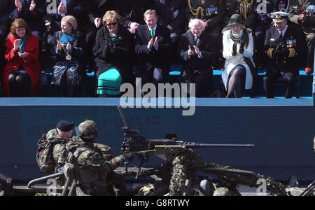 Taoiseach Enda Kenny (centro) e il presidente Michael D Higgins (terza a destra) guardano la più grande parata militare nella storia dello stato mentre passa il GPO come parte delle commemorazioni del centenario della rivolta di Pasqua del 1916 a Dublino. Foto Stock