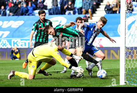 Il Conor McAleny di Wigan Athletic segna il primo goal alle sue squadre oltre l'Ashley Eastham di Rochdale e il portiere Josh Lillis, durante la partita della Sky Bet League One al DW Stadium di Wigan Foto Stock