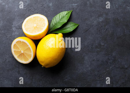 Freschi limoni maturi in pietra scura sullo sfondo. Vista da sopra con lo spazio di copia Foto Stock