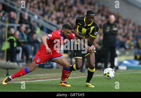 Lucas Atkins di Burton Albion combatte per la palla con Oldham Pareiq Holmes-Dennis di Athletic Foto Stock