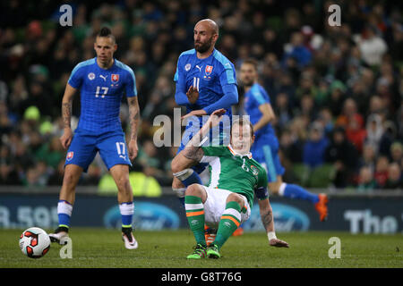 Glenn Whelan della Repubblica d'Irlanda e Robert Vittek (centro) della Slovacchia combattono per la palla durante un amichevole internazionale all'Aviva Stadium, Dublino. Foto Stock