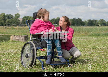 Un disabile su sedia a rotelle rilassarsi con l aiuto di un volontario lavoratore di cura Foto Stock