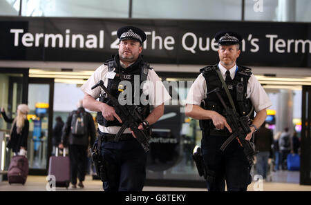 Ufficiali di polizia armati pattugliano regolarmente al Terminal 2 di Heathrow, a ovest di Londra, dopo gli attacchi terroristici di ieri nella capitale belga Bruxelles. Foto Stock