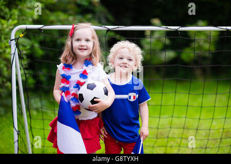 Bambini il tifo e il sostegno nazionale francese di calcio. I ragazzi appassionati e sostenitori della Francia durante il campionato di calcio. Foto Stock