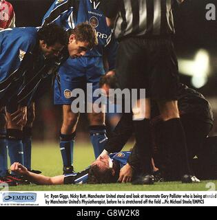 Ryan Giggs (a sinistra) e Phil Neville (seconda a sinistra) del Manchester United si piegano sopra il compagno di squadra Gary Pallister (al piano) mentre riceve l'attenzione dal fisioterapista del Manchester United (a destra) Foto Stock