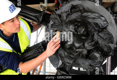 Conservatore di sculture freelance Scarlett Hutchin, lavorando per il patrimonio inglese, lucido di cera di buffs applicato al mozzo di una ruota di carri sulla scultura dell'artista Adrian Jones, Quadriga, in cima al Wellington Arch a Hyde Park Corner, raffigurante quattro cavalli, che rappresentano le forze del caos e della guerra che tirano un carro, Essere calmato dall'angelo della pace, come la scultura simbolo è in fase di pulizia, riparazione e ri-waxed da un team di specialisti come parte di un importante programma di conservazione del patrimonio inglese. Foto Stock