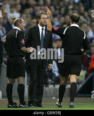 Alain Perrin (C), direttore di Portsmouth, è ordinato al passo dall'arbitro Mark Clattenburg (R). Perrin è stato licenziato dal dugout in tempo di infortunio dopo aver criticato l'arbitro Clattenburg secondi dopo che il funzionario aveva ammonito Brian Priske di prendere un tiro dal posto sbagliato. Foto Stock