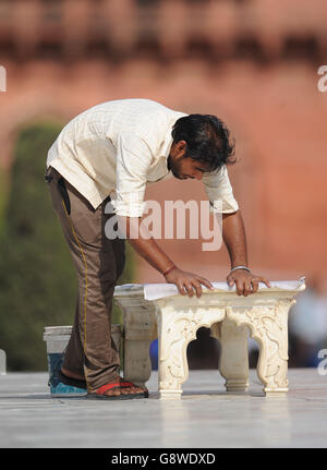 Un uomo pulisce una panchina per il duca e la duchessa di Cambridge a sedersi durante la loro visita al Taj Mahal in India durante il giorno 7 del giro reale in India e Bhutan. Foto Stock