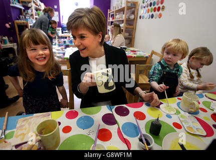 Il leader della SNP Nicola Sturgeon dipinge le tazze con Freya Finnie (a sinistra) e Zac e Emily Sturgeon (senza relazione) durante una visita alla Ceramica smaltata a Glasgow sul percorso della campagna elettorale. Foto Stock