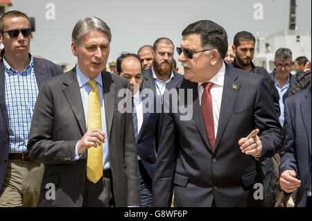 Il Segretario degli Esteri Philip Hammond, a sinistra, visita una base navale con il primo Ministro designato della Libia Fayez Sarraj durante la sua visita a Tripoli, Libia. Foto Stock