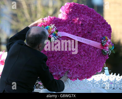 Fiori in cima a un cuore trainato da cavalli che porta la bara di Paige Doherty, 15 anni, quando arriva alla Chiesa cattolica di Santa Margherita a Clydebank, per una messa privata che riceve davanti al suo funerale domani. Foto Stock