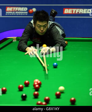 Liang Wenbo in azione contro Judd Trump durante il quinto giorno dei Campionati Mondiali di Snooker di Betfred al Crucible Theatre di Sheffield. Foto Stock