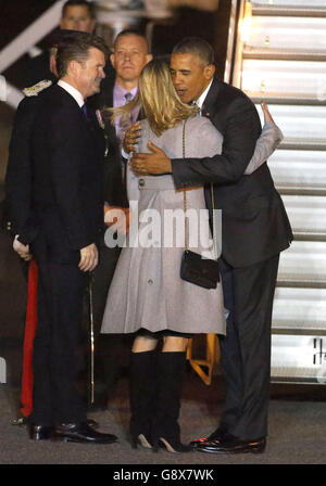 Il presidente DEGLI STATI UNITI Barack Obama abbraccia Brooke Brown Barzun, moglie dell'ambasciatore americano Matthew Barzun (a sinistra) quando arriva all'aeroporto di Stansted per una visita nel Regno Unito. Foto Stock