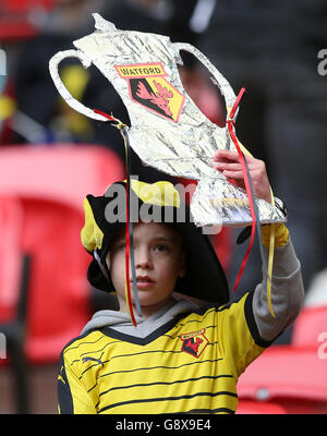 Un giovane fan di Watford tiene una tazza di cartone fa negli stand prima della Emirates fa Cup, partita semifinale al Wembley Stadium di Londra. Foto Stock
