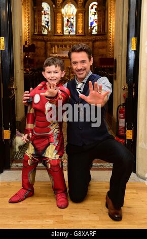 L'attore di Iron Man Robert Downey Jr incontra il Seven-year-old Ethan Miller, di Southend, Essex, che soffre della rara malattia del sangue ITP e del diabete di tipo 1, durante una visita al Great Ormond Street Hospital (GOSH), a Londra, prima della prima europea di Captain America: Guerra civile a Londra il 26 aprile, la star del film trascorse il pomeriggio visitando i pazienti e le loro famiglie e consegnando i regali del Capitano America. Foto Stock