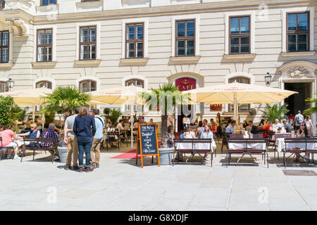 Le persone sulla terrazza esterna della Hofburg cafe nel Castello interiore corte In der Burg nel centro di Vienna, Austria Foto Stock