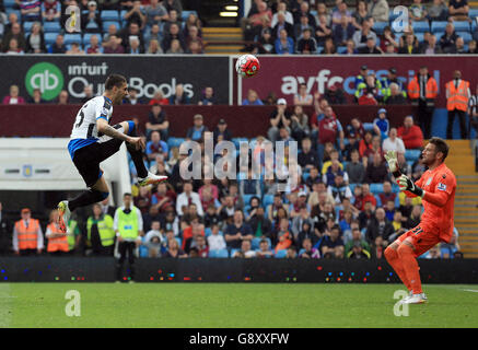 Aleksandar Mitrovic (a sinistra) di Newcastle United solleva un colpo sul portiere di Aston Villa Mark Bunn durante la partita Barclays Premier League a Villa Park, Birmingham. Foto Stock