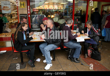 I fan di West Ham United si mangiano un boccone prima della partita finale all'Upton Park, Londra. Foto Stock