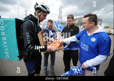 Un pilota Deliveroo consegna omaggi da Peter Pizzeria ai fan del Leicester City FC fuori dal King Power Stadium di Leicester, prima che il team sollevi il trofeo Barclays Premier League questo fine settimana. Foto Stock