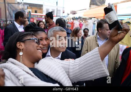 Sadiq Khan, candidato laburista per il sindaco di Londra, incontra acquirenti e commercianti sul mercato di East Street a Walworth, a sud-est di Londra, alla vigilia delle elezioni del sindaco. Foto Stock