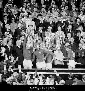 Il Capitano d'Inghilterra Bobby Moore tiene in mano il Jules Rimet Trophy, seguito da Geoff Hurst, Bobby Charlton e Roger Hunt (medaglia di ricezione della Regina). Foto Stock