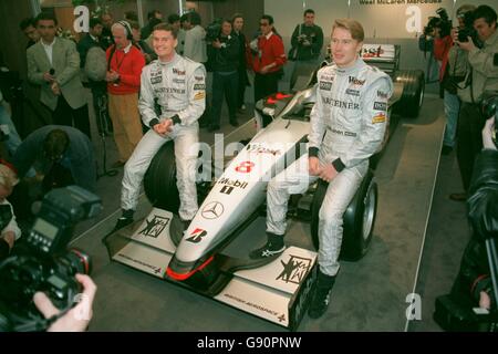 Formula uno Motor Racing - lancio della McLaren. David Coulthard (a destra) e Mika Hakkinen (a sinistra) siedono sulle ruote della nuova McLaren MP4-13 Foto Stock