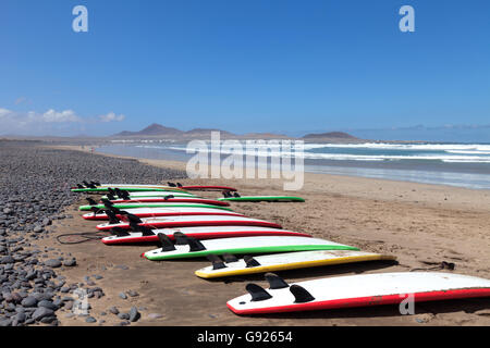 Tavole da surf schierate sulla spiaggia Playa de Famara lanzarote Foto Stock