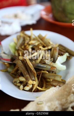 Agitare piccante fritti cannolicchi con curry rosso e cipolla Foto Stock