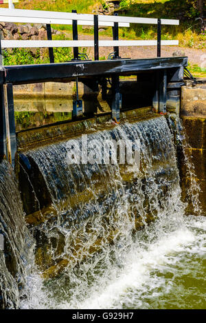 L'acqua che scorre lentamente sopra la parte superiore di un canale chiuso blocca a Gota canal. Foto Stock