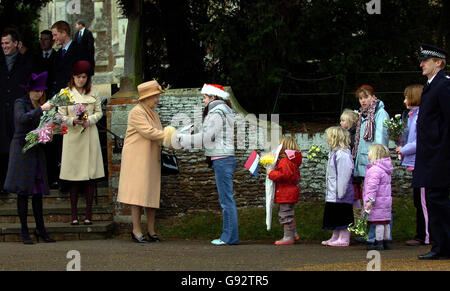 La Regina Elisabetta II riceve fiori dai bambini dopo il servizio di Natale alla Chiesa di Santa Maria Maddalena nella tenuta di Sandringham a Norfolk, domenica 25 dicembre 2005. Vedi la storia della Chiesa REALE di PA. PREMERE ASSOCIAZIONE foto. Il credito fotografico dovrebbe essere: Chris Radburn/WPA Rota/PA Foto Stock