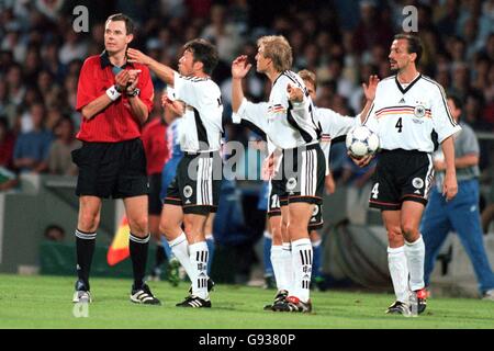 Lothar Matthaus in Germania (seconda a sinistra), Jurgen Klinsmann (seconda a destra) e Jurgen Kohler (destra) discutono con l'arbitro Rune Pedersen (sinistra) dopo che i verni cristiani sono stati mandati via Foto Stock