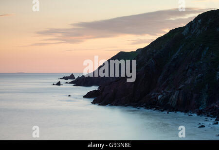 Tramonto in cima alla scogliera vista lungo Il Pembrokeshire Coast a Westdale Bay guardando verso Skomer. Foto Stock