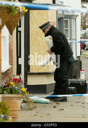 Un ufficiale di polizia depone fiori giovedì 26 gennaio 2006, a nome della comunità fuori casa in Abbey Street, Faversham, Kent, di una coppia anziana sposata che è stata scoperta morta mercoledì presto da un parente che ha chiamato alla casa che hanno condiviso per più di 40 anni. Il loro berline viola Daihatsu Sirion a cinque porte è stato trovato bruciato in un vicolo altrove a Faversham intorno alle 18:00 di Lunedi. Vedi PA storia CORPI DI POLIZIA. PREMERE ASSOCIAZIONE foto. Il credito fotografico dovrebbe essere: Gareth Fulller. Foto Stock