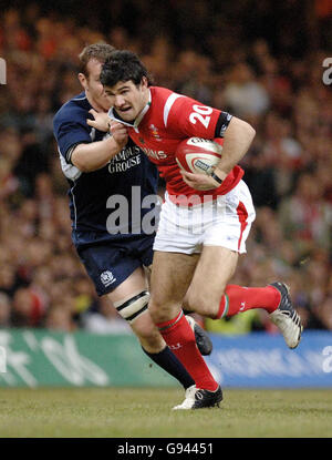 Mike Phillips del Galles consegna John Petrie della Scozia durante la partita RBS 6 Nations al Millennium Stadium di Cardiff, domenica 12 febbraio 2006. PREMERE ASSOCIAZIONE foto. Il credito fotografico dovrebbe essere: David Jones/PA. Foto Stock