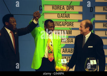 La superstar brasiliana Pele (l) alza il braccio di Abedi Pele (al centro) durante l'ultimo Campionato del mondo di qualificazione per la regione di Conmebol, che si è tenuto a New York, USA. Il Segretario Generale Sepp Blatter (r) si occupa. Foto Stock