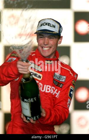 Richard Burns in Inghilterra sprizza champagne per festeggiare la vittoria del Rally di Gran Bretagna, sul podio di Cheltenham Foto Stock