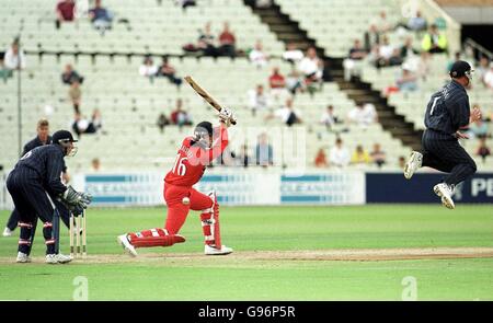 John Crawley del Lancashire colpisce un azionamento verso il confine AS Dougie Brown del Warwickshire prende azione evasiva Foto Stock