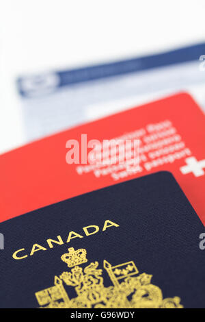 I passaporti con modulo doganale. passaporto canadese nel fuoco e swiss con luce di sfocatura. Foto Stock