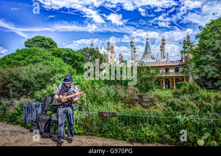 Busker con chitarra elettrica nella Royal Pavillion Gardens Brighton con il Royal Pavillion visibile in background Foto Stock