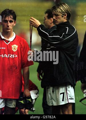 Calcio - UEFA Super Cup - Lazio / Manchester United. David Beckham del Manchester United si alza in piedi abbattuto Lazio sollevare il trofeo UEFA super Cup Foto Stock