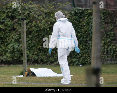 ANNOTARE IL CONTENUTO GRAFICO. Un ufficiale forense della polizia passa davanti a un corpo coperto dopo un tiro nei pressi del pub Brass Handles a Salford, Manchester, domenica 12 marzo 2006. Due persone sono state uccise e altre due sono rimaste ferite dopo le sparatorie, ha detto oggi la polizia. Gli ufficiali sono stati chiamati al pub intorno alle 14.30 oggi, dopo le notizie di colpi di pistola. Le due persone ferite sono state ricoverate in ospedale, ma la loro entità non è nota. Vedi PA Story POLIZIA Shooting. PREMERE ASSOCIAZIONE foto. Il credito fotografico dovrebbe essere: Martin Rickett/PA. Foto Stock