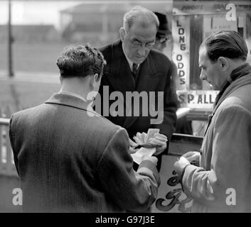 Corse Greyhound - Stadio Hackney Wick. Un bookmaker paga fuori ad un punter vincente Foto Stock