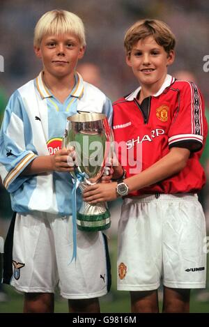 Calcio - UEFA Super Cup - Lazio / Manchester United. Bambini vestiti in divise del Lazio e del Manchester United con una replica in miniatura della UEFA Super Cup Foto Stock