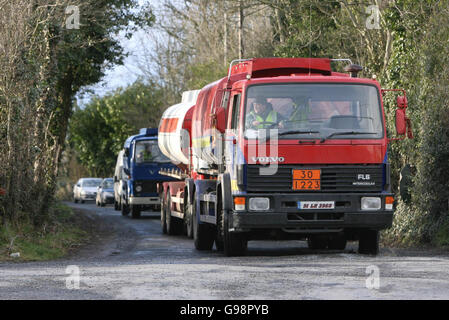 Gli ufficiali del Garda rimuovono le autocisterne dalla scena di una importante operazione di ricerca transfrontaliera nei pressi di Crossmaglen in Co Armagh, giovedì 9 marzo 2006. Tre persone sono state arrestate durante una massiccia operazione di sicurezza legata a un'indagine importante sulla criminalità organizzata su entrambe le sponde del confine irlandese. Centinaia di poliziotti e soldati nel sud di Armagh e nel nord di Co Louth hanno fatto irruzione nelle proprietà e, ad un certo punto, un'area intorno alla casa di famiglia di Thomas 'Slab' Murphy, 62, presumibilmente il capo di stato maggiore dell'IRA, è stata sigillata. PREMERE ASSOCIAZIONE foto. Il credito fotografico dovrebbe essere: Niall Carson/PA Foto Stock