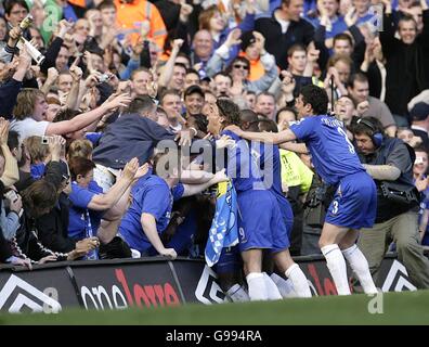 Michael Essien di Chelsea festeggia il terzo obiettivo del gioca con i compagni di squadra davanti al supporto domestico Foto Stock